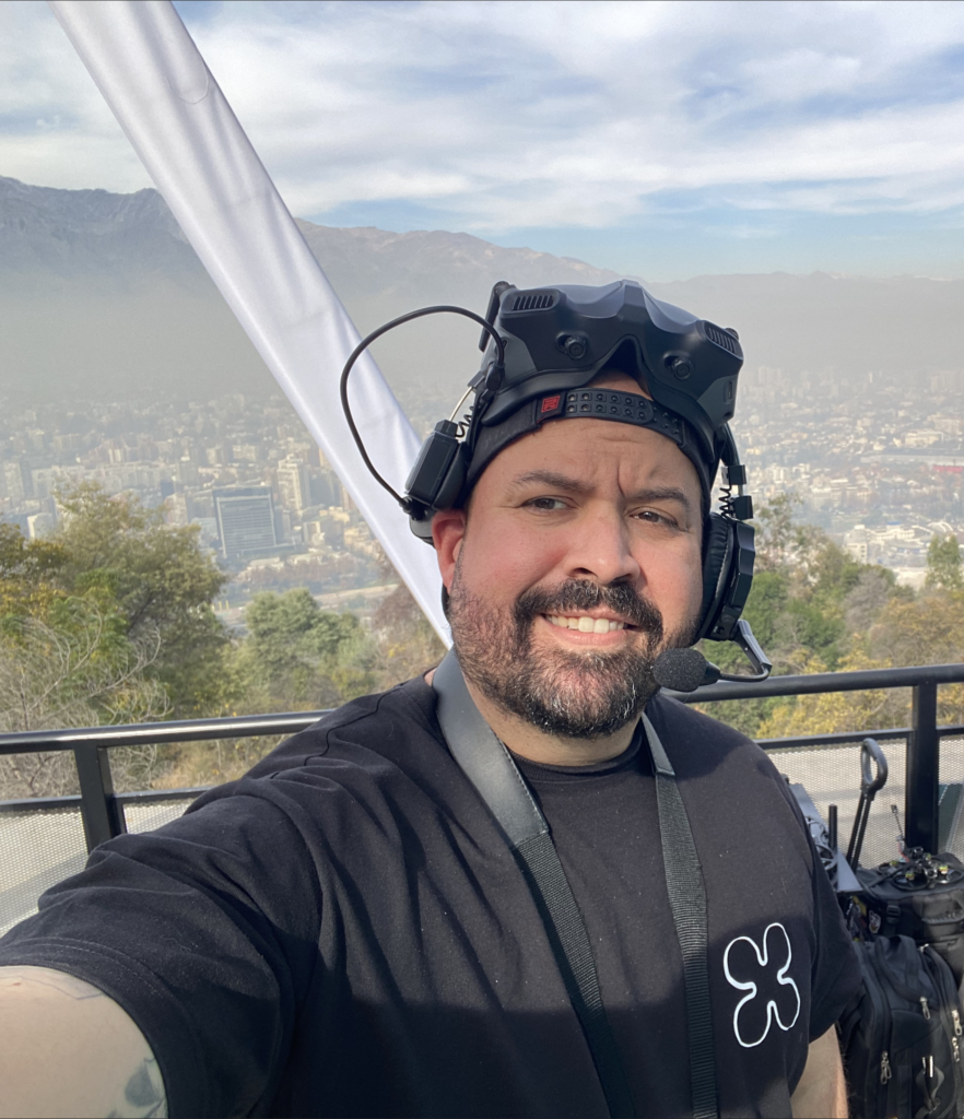 Manuel, piloto de Megdrones, con gafas FPV y la ciudad y la cordillera de fondo